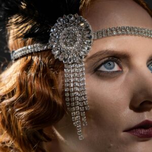 Elegant close-up portrait of a redheaded woman with a glamorous 1920s-inspired look and tiara.